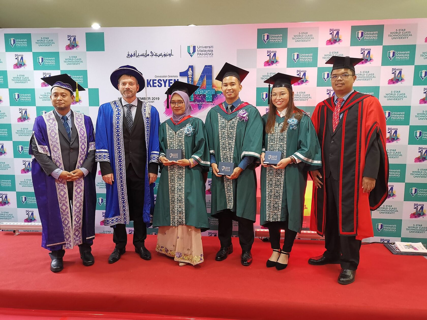group of young people in robes and mortarboards at a Malaysian graduation ceremony