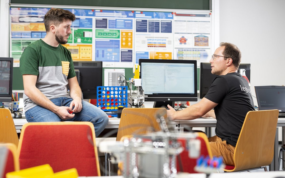 two students with computer in a seminar room, discussing
