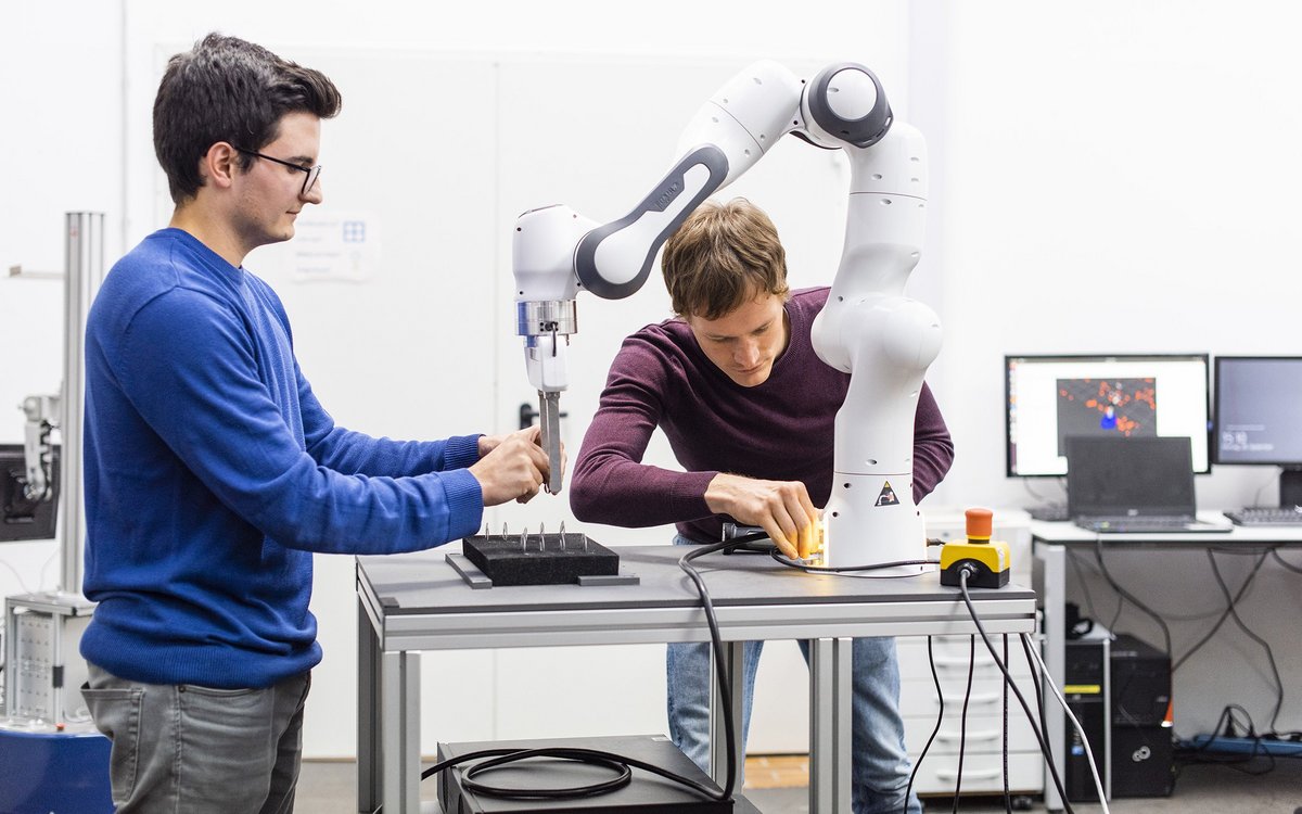 students experiment with an industrial robot at the lab