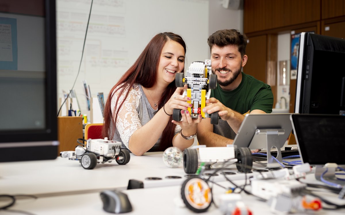 two young people building a robot together
