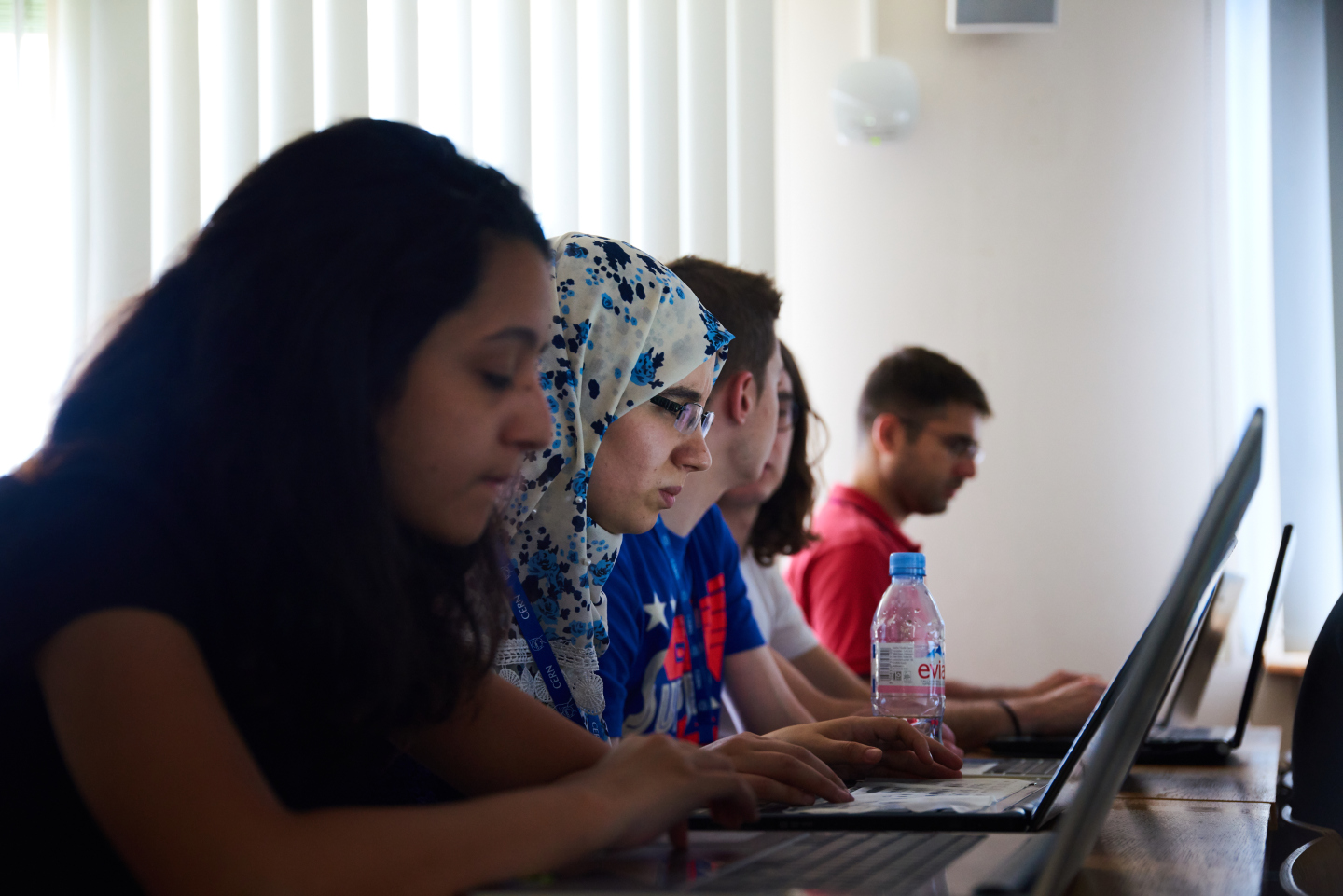 Internationale CERN-Praktikant*innen vor Laptop
