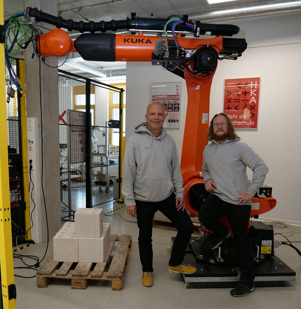Prof. Dr.-Ing. Christian Wurll und Prof. Dr. Ing.-habil. Björn Hein vor einem KUKA Industrieroboter Prof. Dr.-Ing. Christian Wurll und Prof. Dr. Ing.-habil. Björn Hein vor einem KUKA Industrieroboter