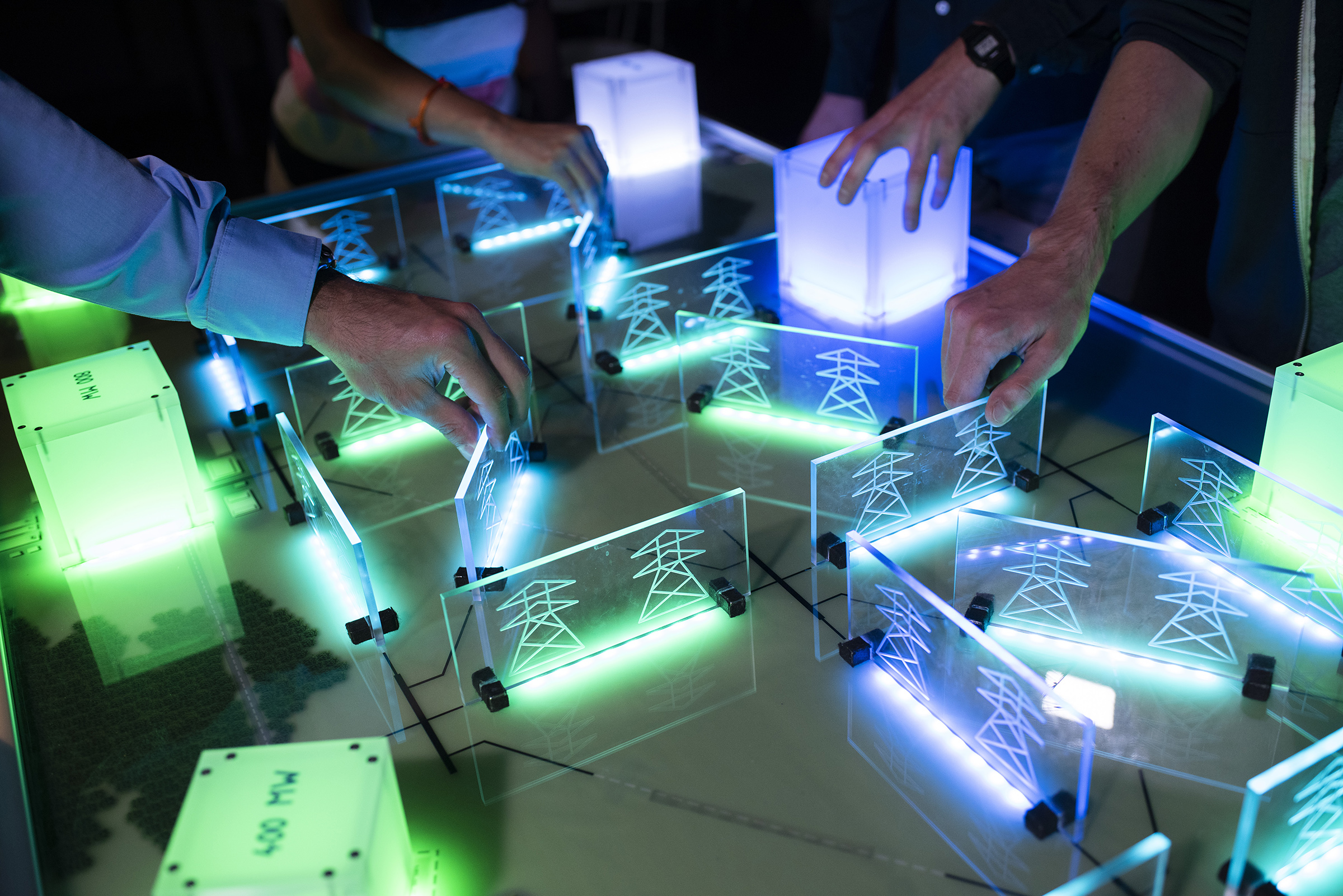 hands moving plexiglass panes depicting overhead power lines