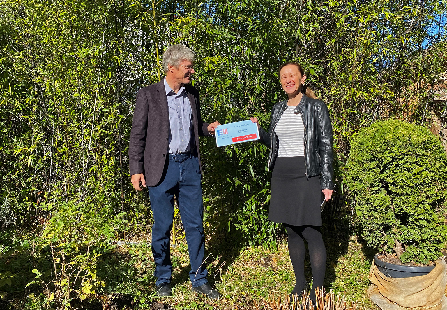 Silvia Schmid giving a cheque to Prof. Dr. habil. Michael Kauffeld for the family of Prof. Noble Banadda