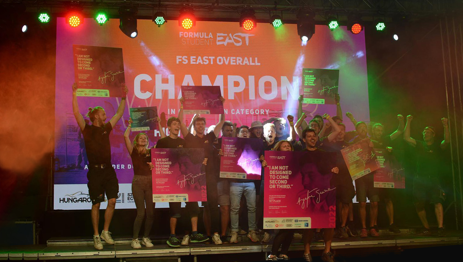 Team at the award ceremony on a stage, cheering