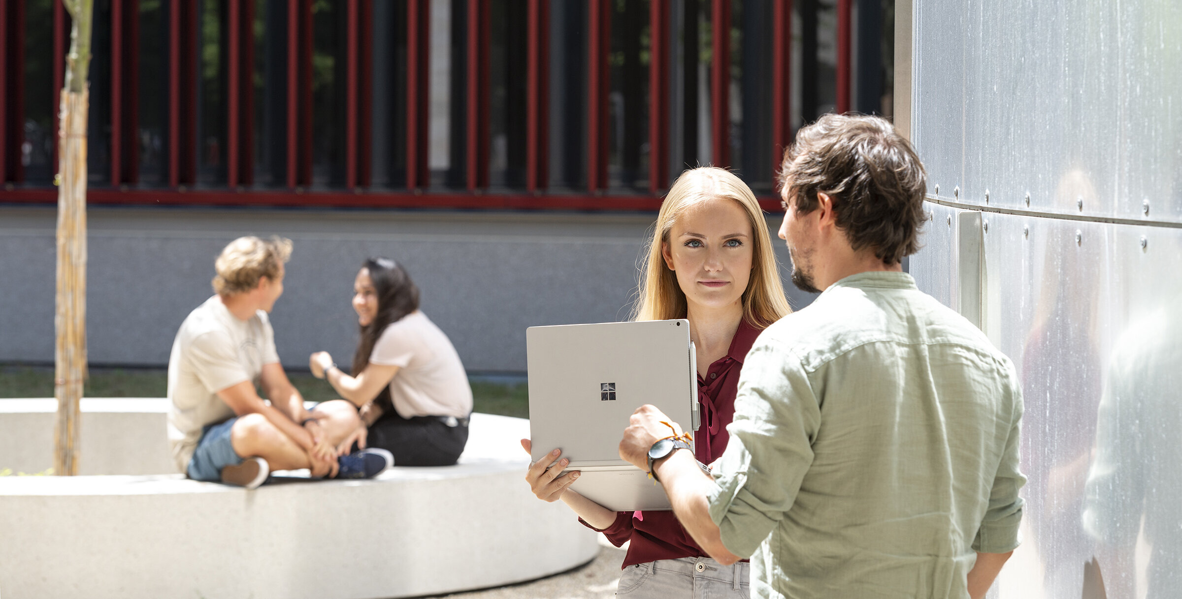 students standing together in small groups on the campus