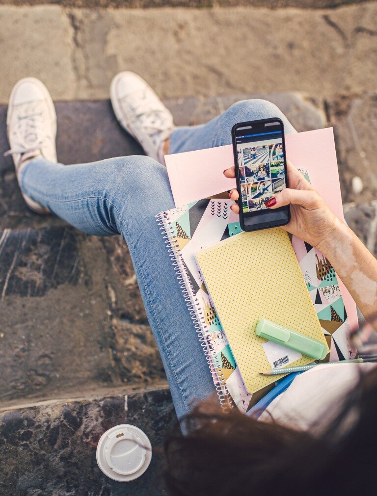 Studentin mit Handy surft auf Instagram