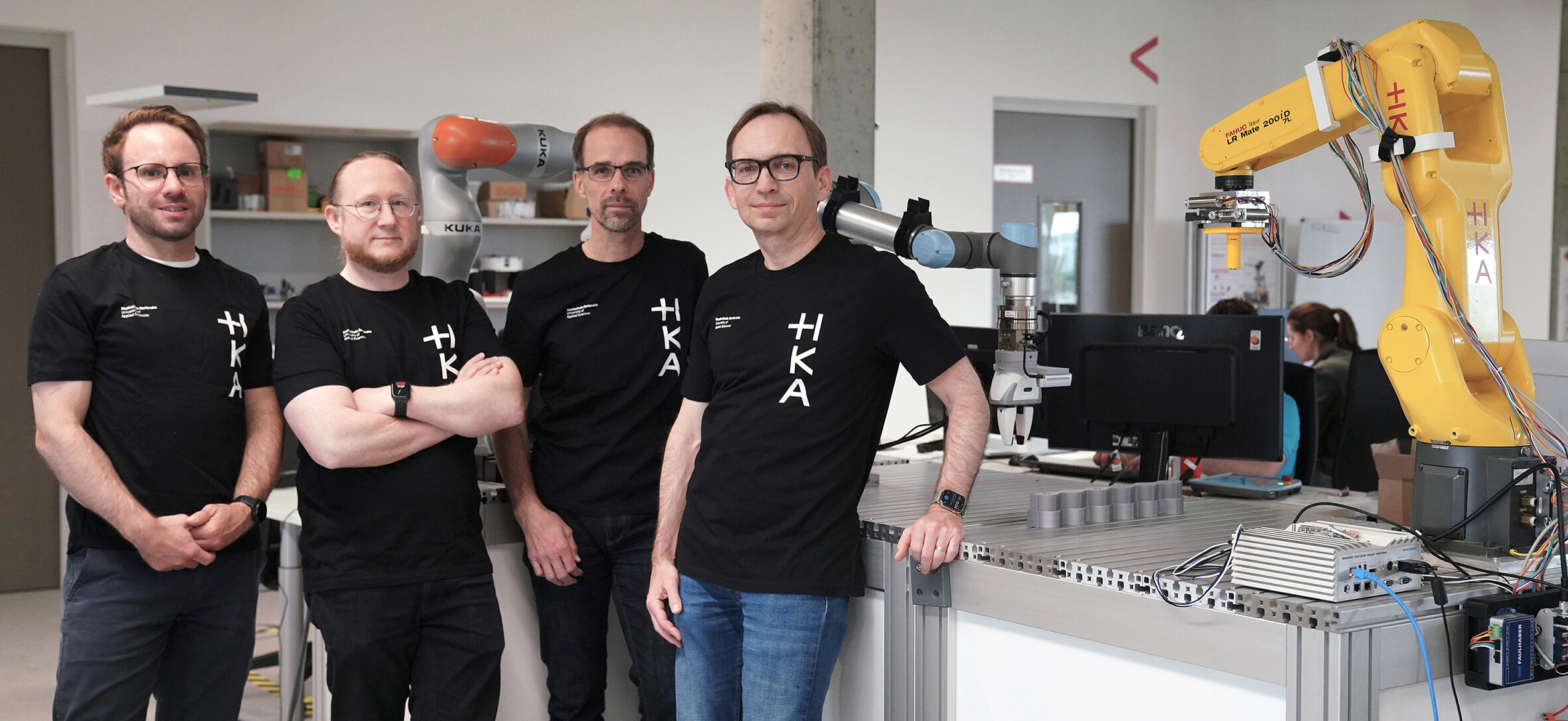 An der HKA entsteht eine neue KI-Plattform, mit der Roboter unternehmensübergreifend lernen können Im Projekt FEATHER forscht ein interdisziplinäres Team der HKA daran, durch föderiertes maschinelles Lernen robotische Systeme verschiedener Unternehmen zu trainieren – direkt vor Ort und ohne Weitergabe sensibler Daten. V. l. n. r.: Christian Friedrich, Björn Hein, Christian Zirpins und Oliver Waldhorst