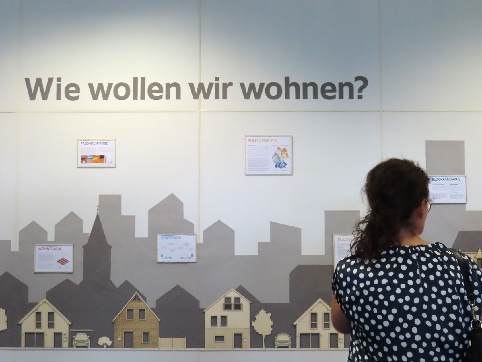 Besucherin vor Wand mit Skyline und Infotafeln