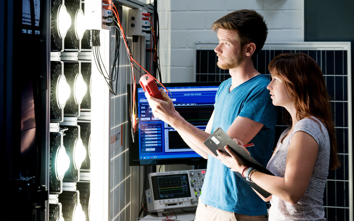 two students programming a wall with diodes