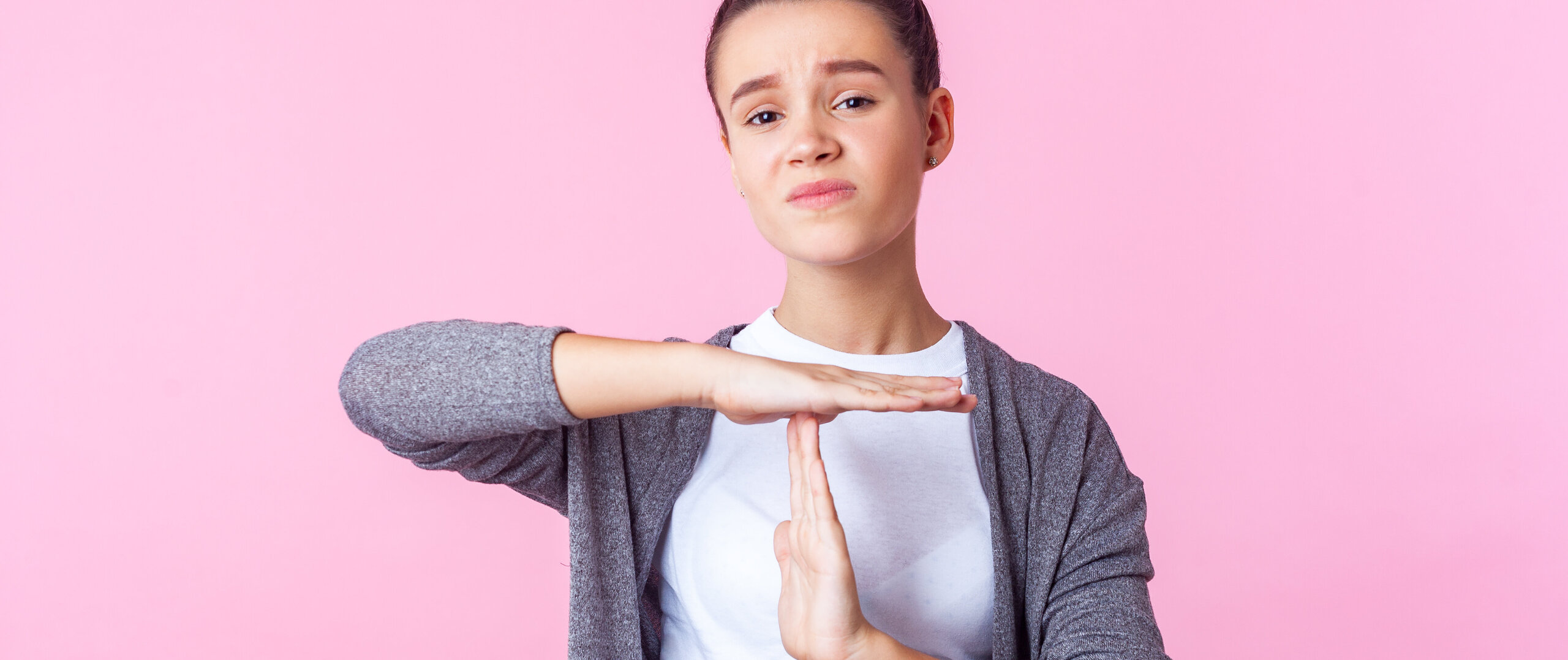 an unhappy young woman showing the "time out"-sign