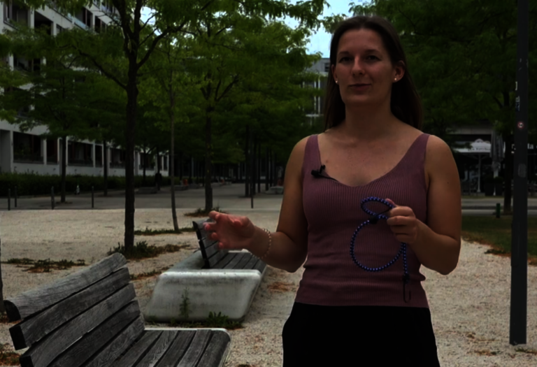 Valerie Duck erläutert etwas mit Expander in der Hand