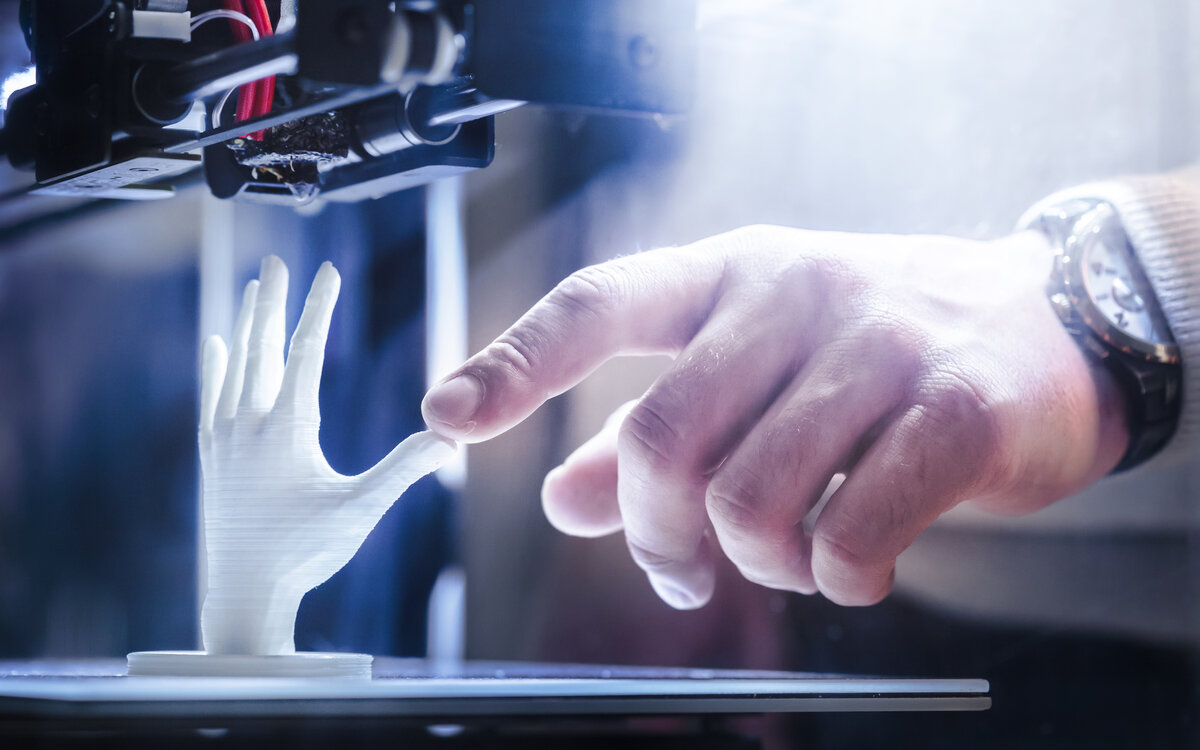 Human hand touching finger on robot hand