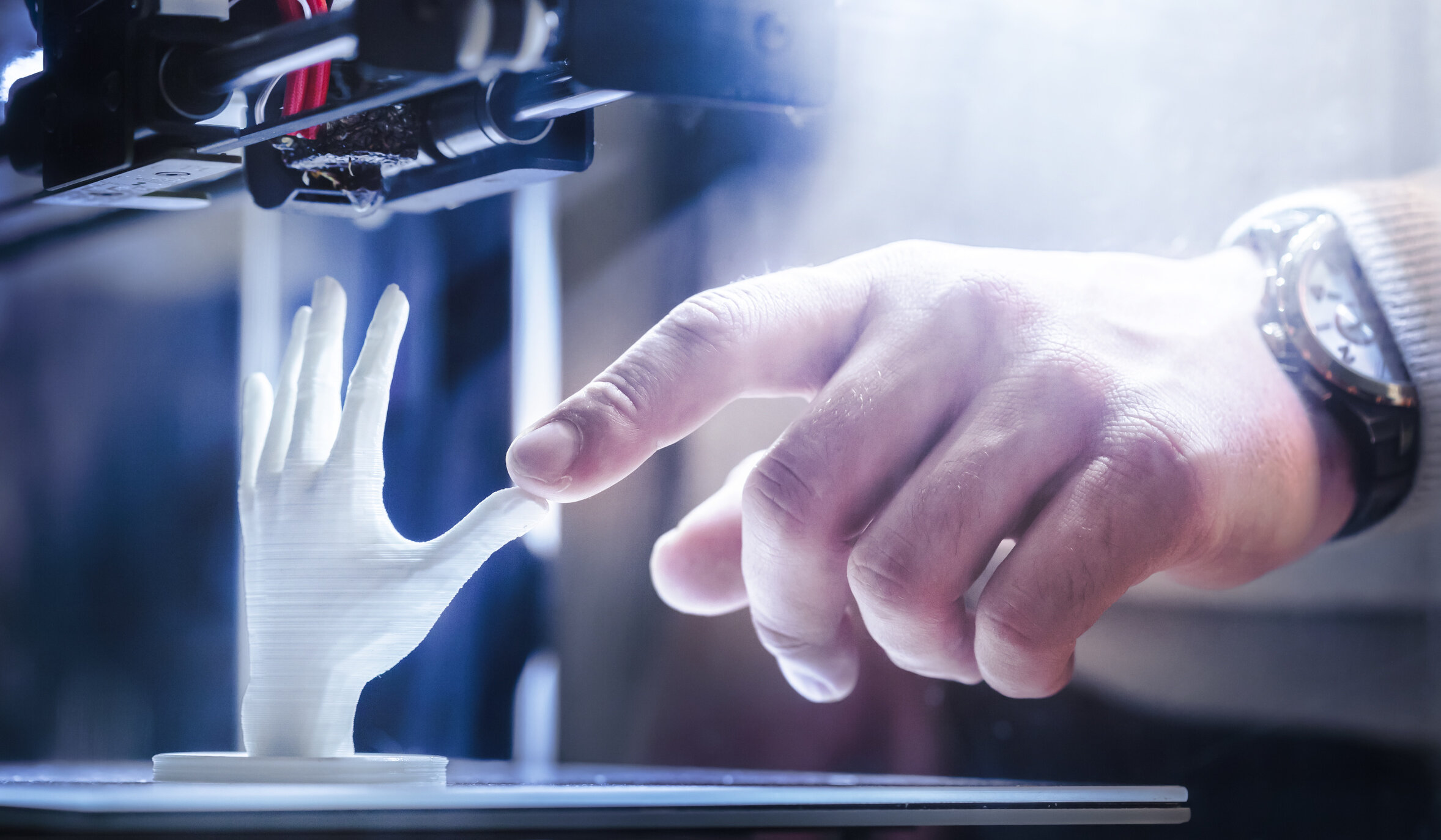 Human hand touching finger on robot hand