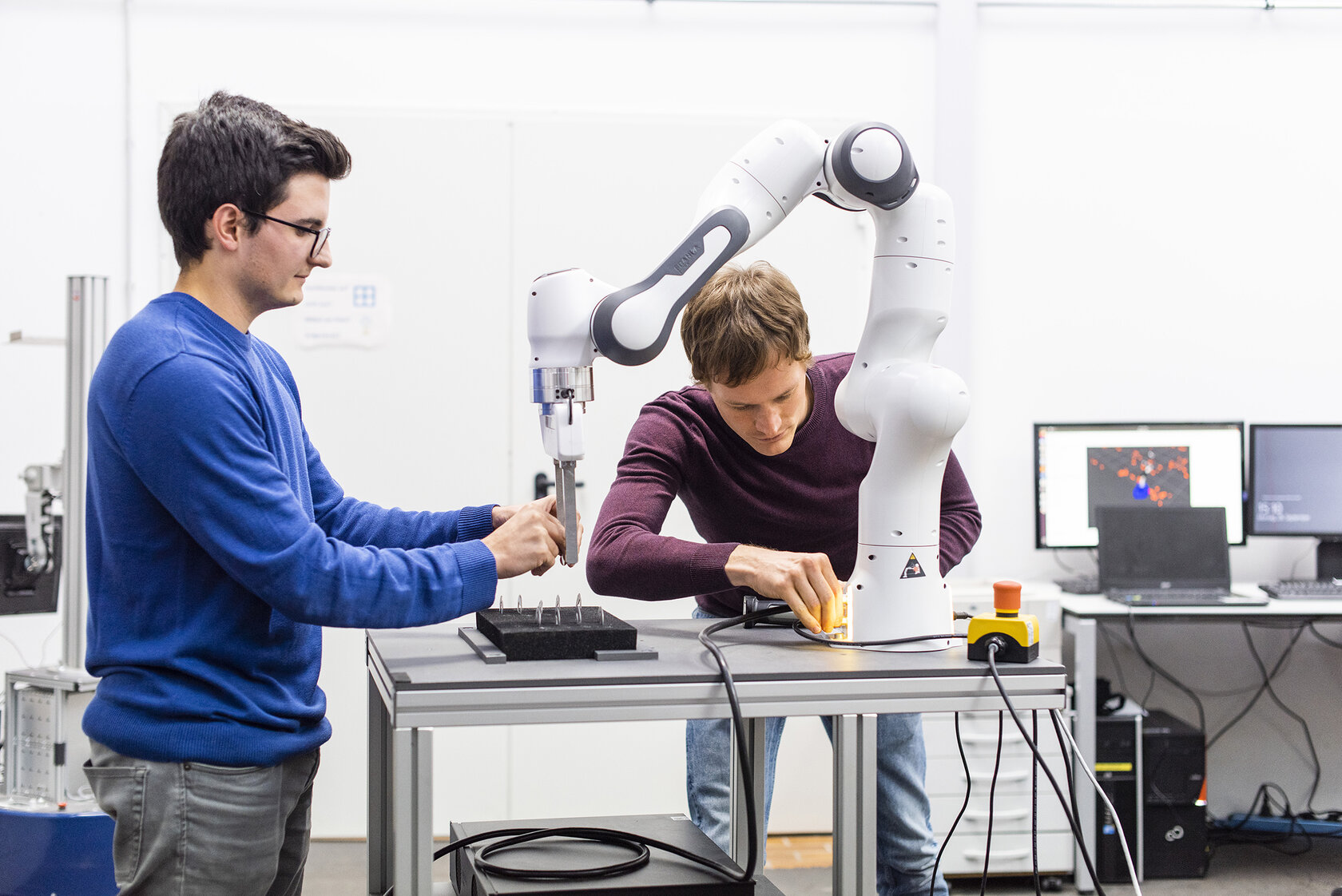 Studierende bei einer Projektarbeit mit einem Roboterarm