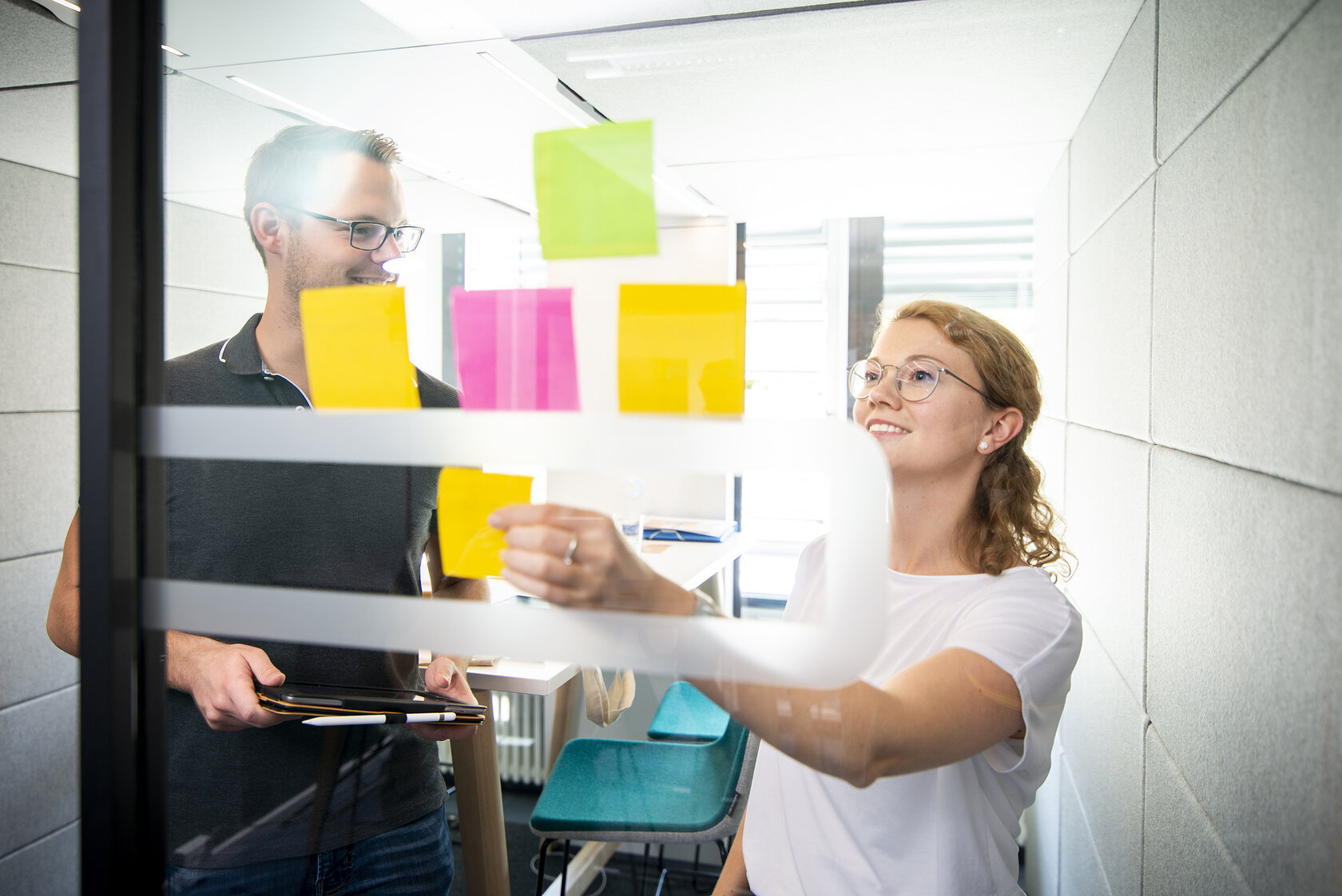 students putting coloured notes on a board