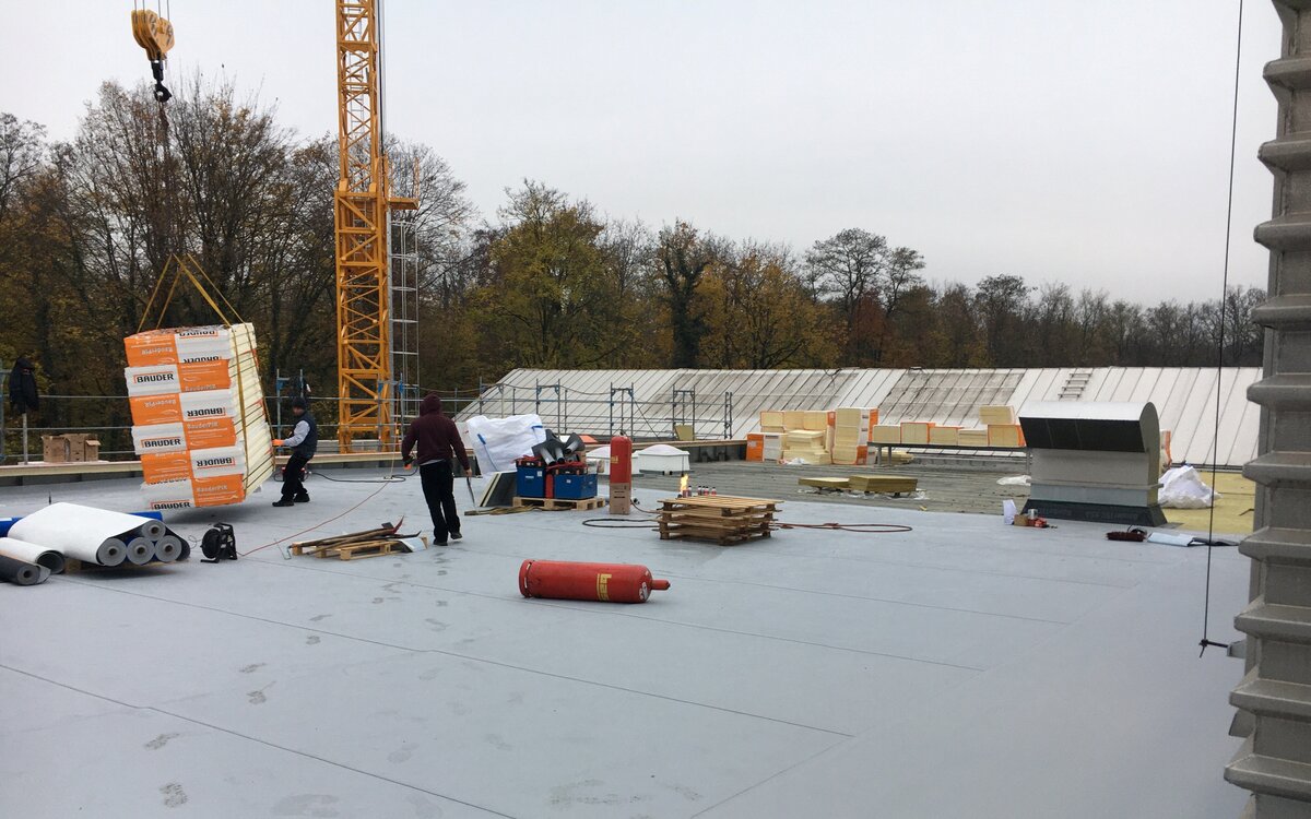 people renovating the roof of the LI building