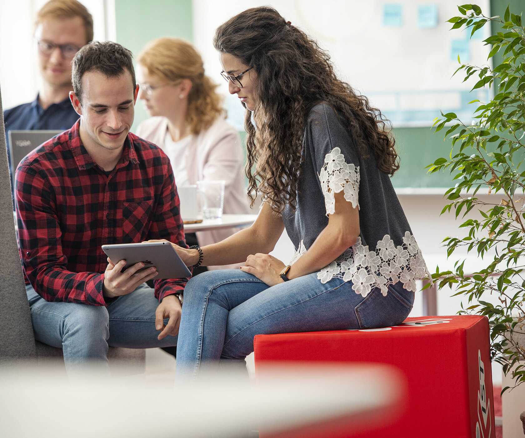 group of students in the lounge area, looking at a laptop