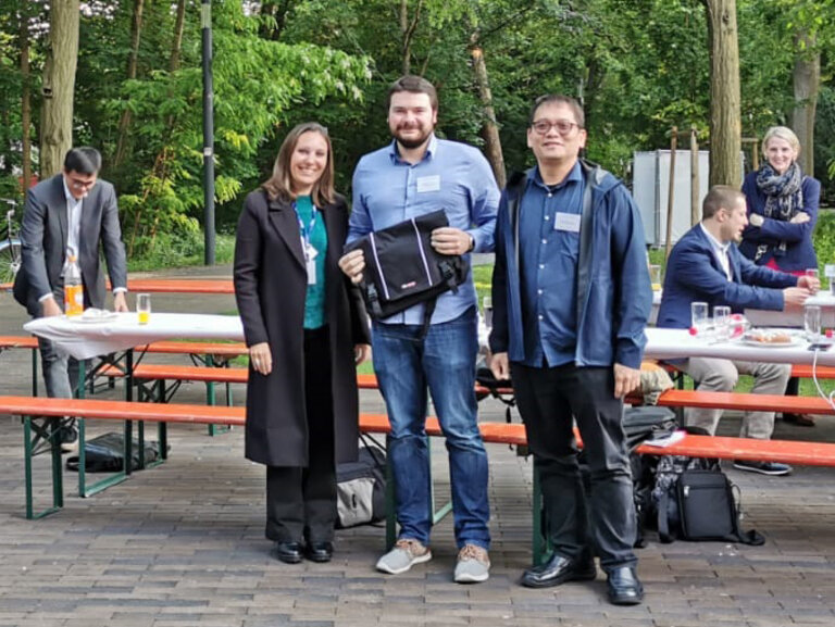 Waldemar Titov (Mitte) erhält den Best Paper Award von zwei Jury-Mitgliedern 