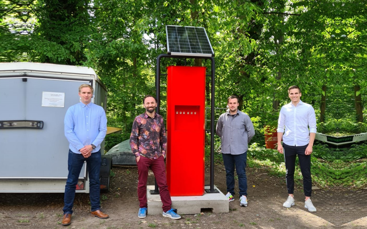 students standing next to the solar charging station
