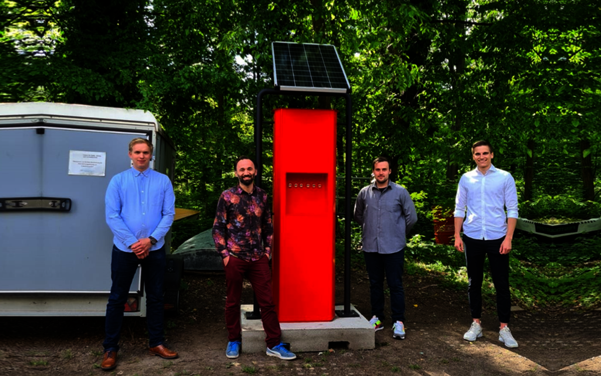 students standing next to the solar charging station