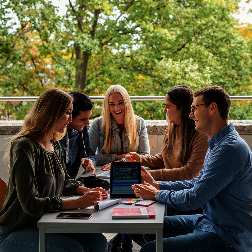 Gruppe von Studierenden am Tisch in der Interaktion