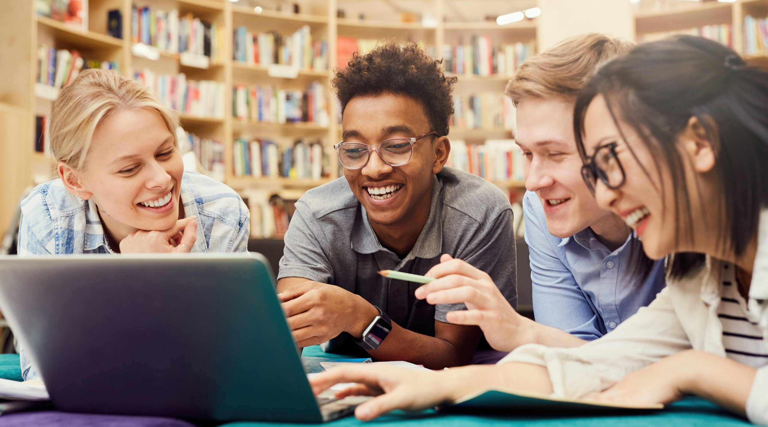 Studierende im Gespräch vor einem offenen Laptop