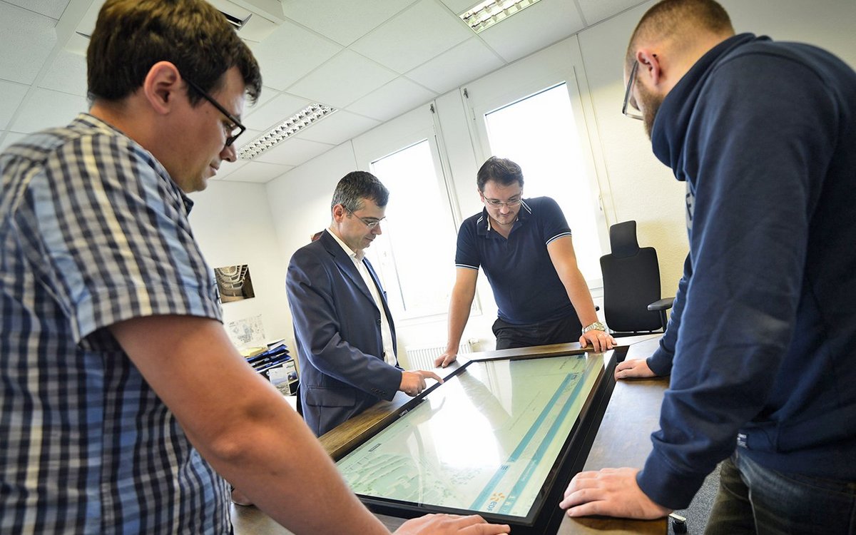 on the interactive Smart Table, the team looks at the SmartCity simulation platform they developed