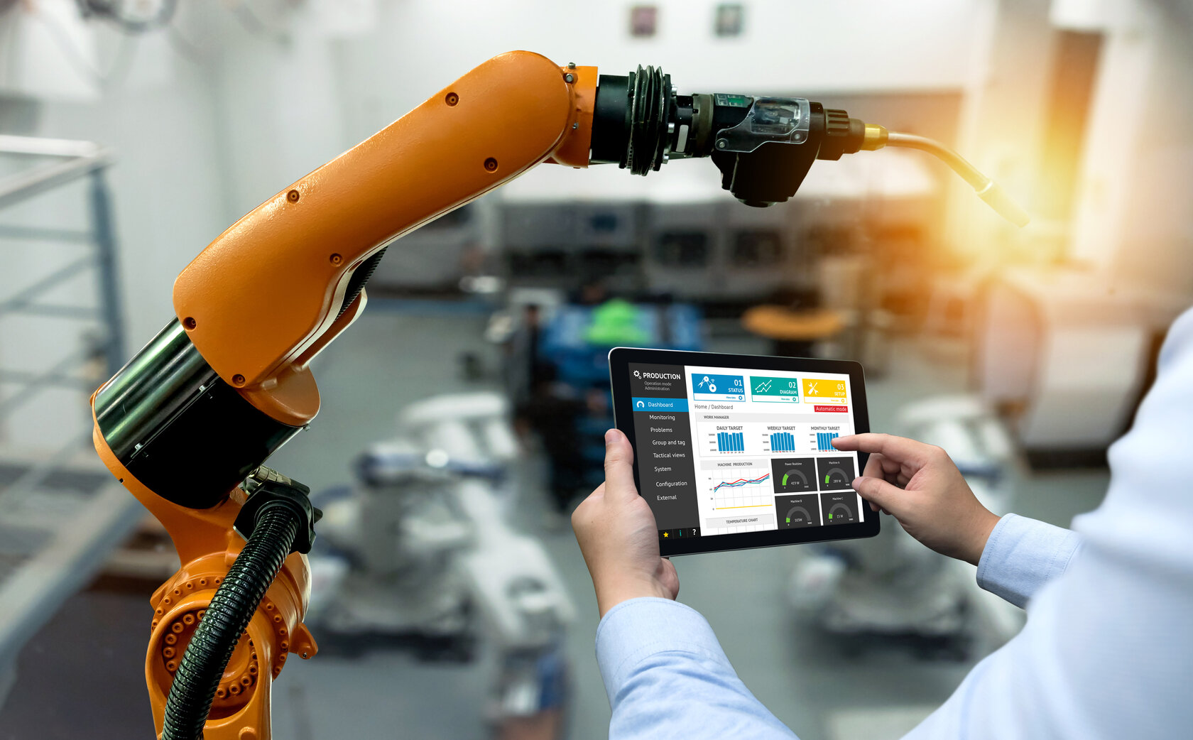 industrial robot, with hands holding operating panel in the foreground