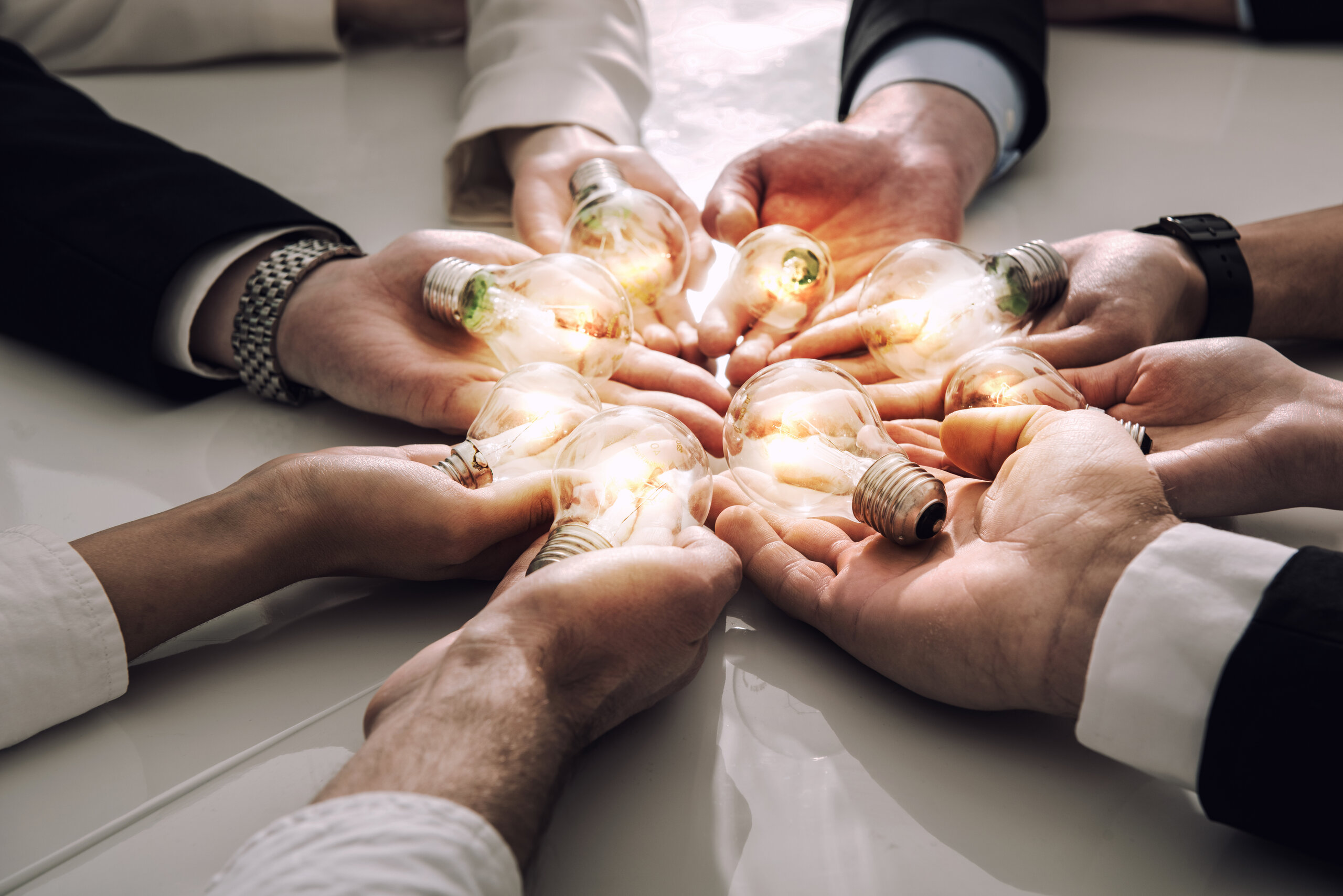 Teamwork and brainstorming concept with businessmen that share an idea with a lamp. Concept company startup