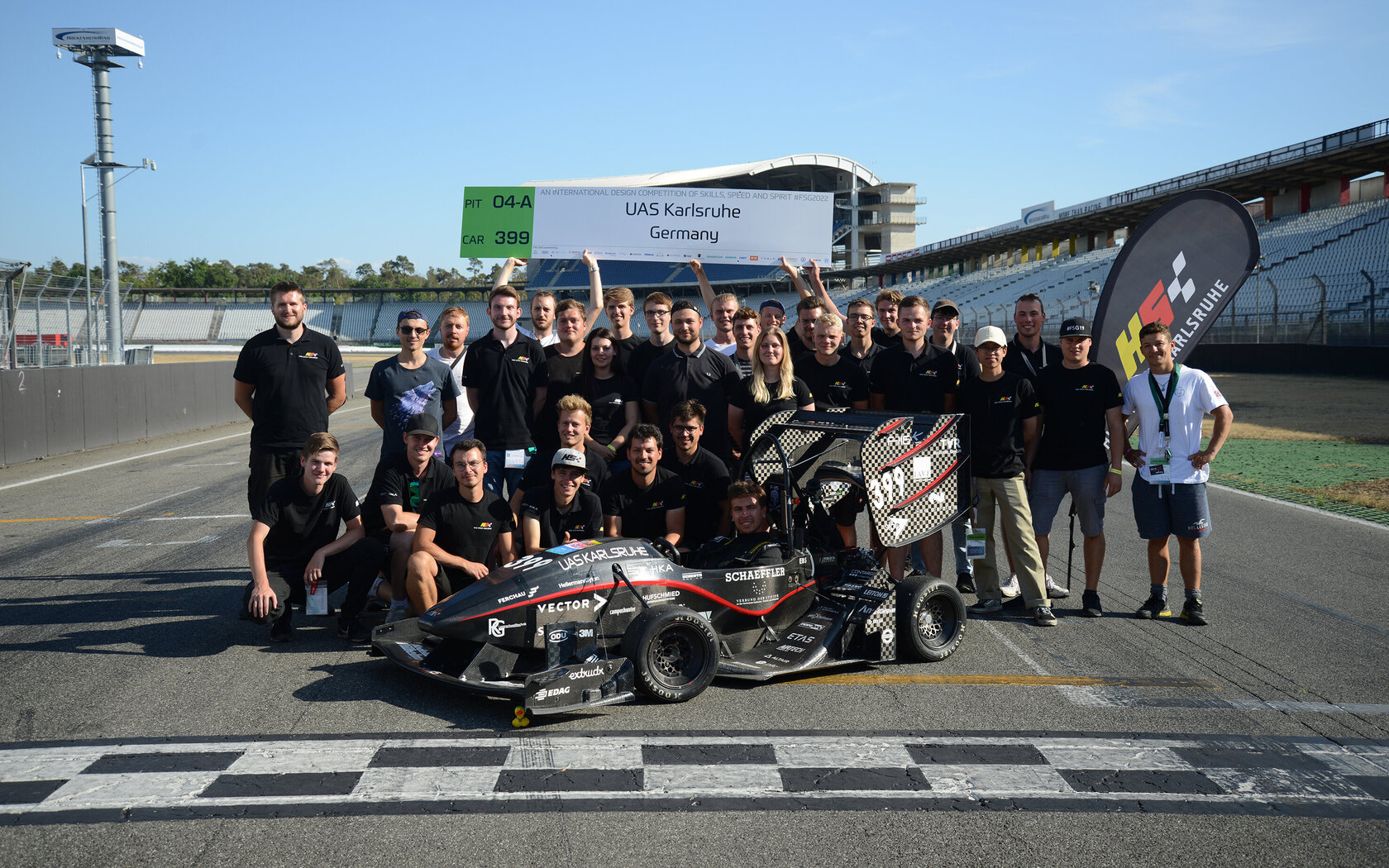 racecar at starting line, with students grouped around it 