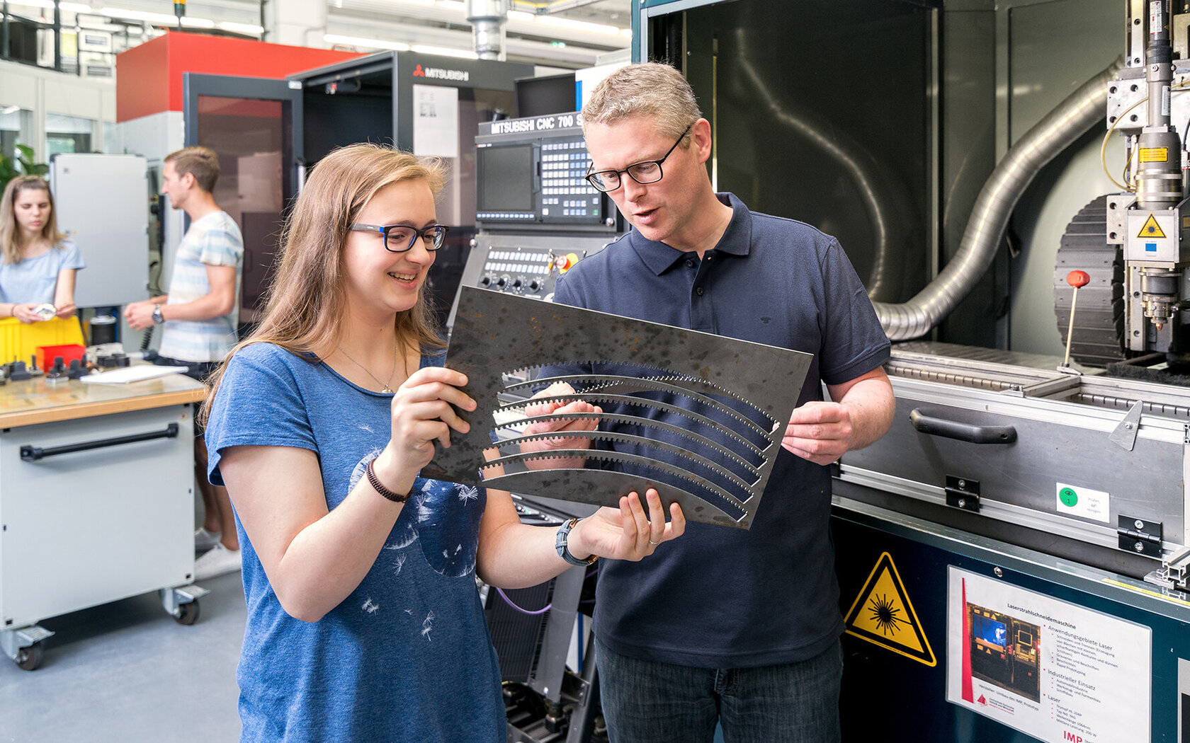 Student/trainee and professor looking at and discussing steel cutting patterns Student/trainee and professor looking at and discussing steel cutting patterns