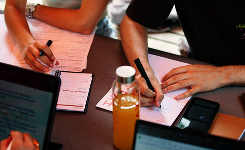 Studierende beim Schreiben und Tippen