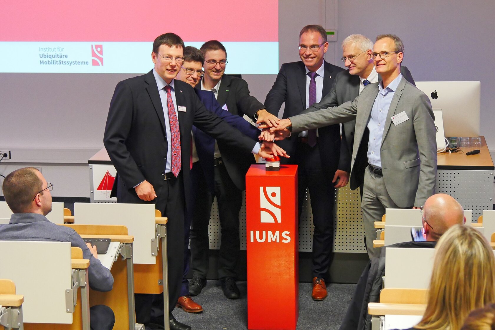 Buzzer-Startschuss zur Eröffnung des IUMS Labors: Prof. Dr.-Ing. Thomas Schlegel, Prof. Dr.-Ing. Christoph Hupfer, Dirk Weißer (Head of Research, init SE), Rektor Prof. Dr.-Ing. Frank Artinger, Prof. Dr. Thomas Ertl, Dr. Wolf Engelbach (v. l .n. r.)