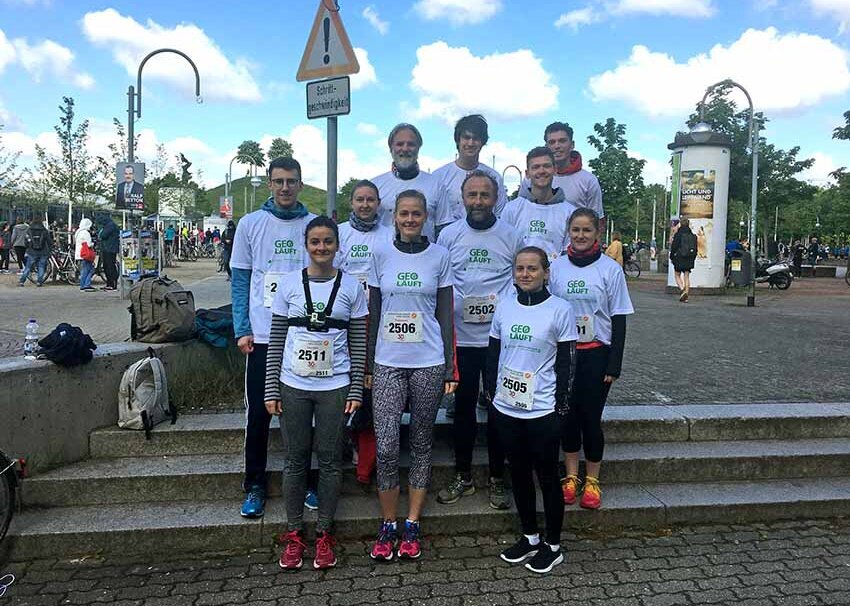 group of participants wearing runner's shoes, identical t-shirts and marathon starter's numbers