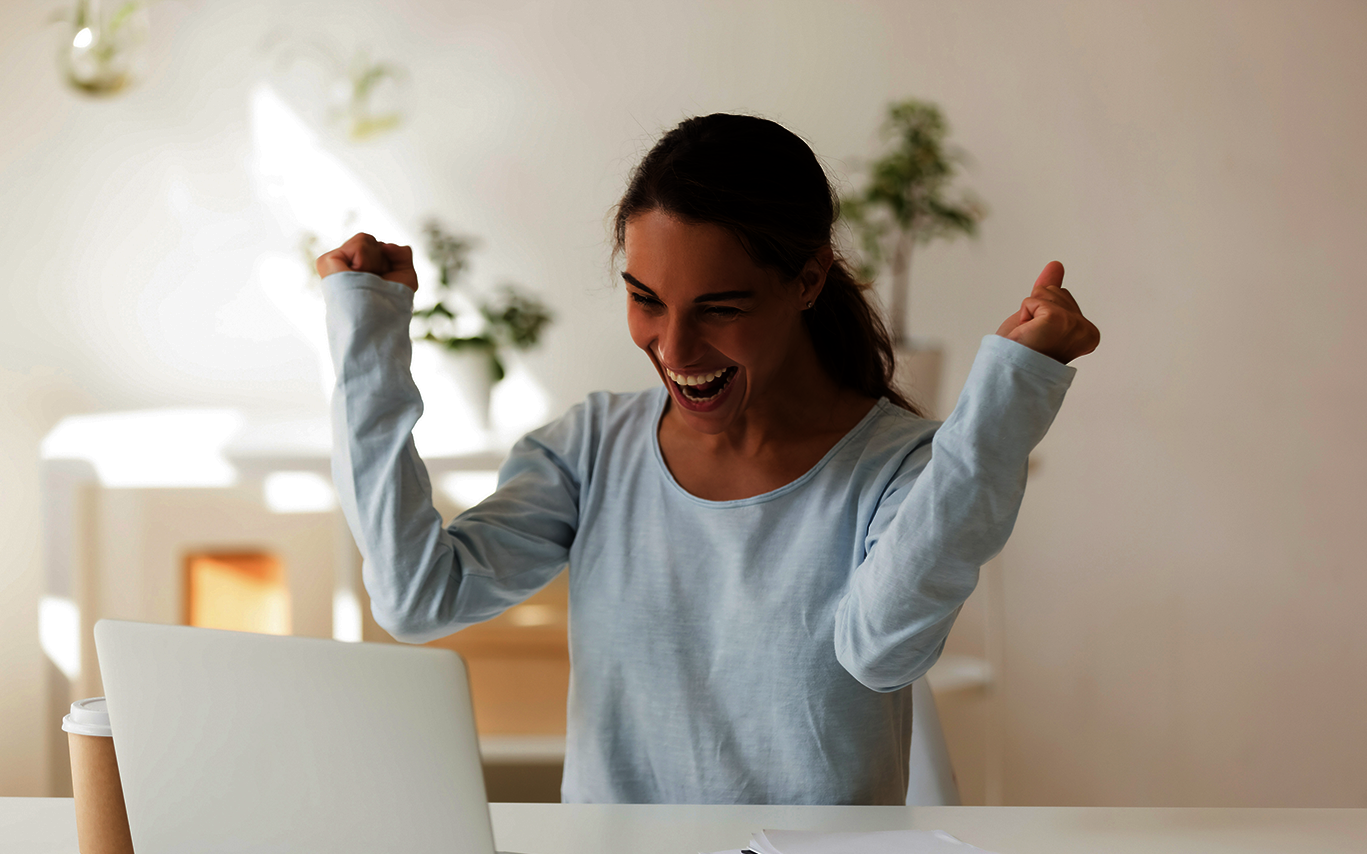 scholarship granted: young woman looks at her screen and rejoices