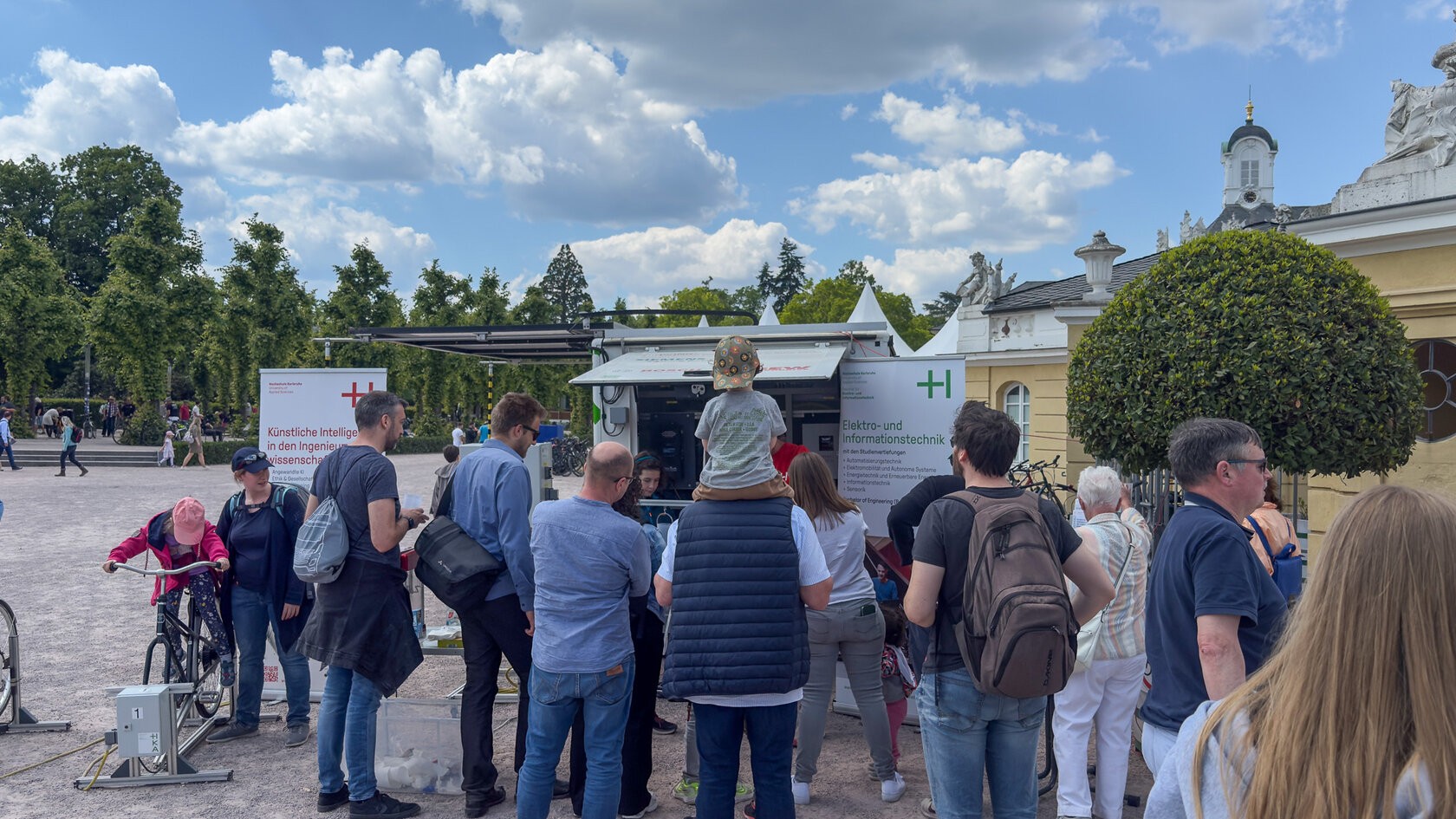 Eine Gruppe Menschen vor einem Stand der HKA