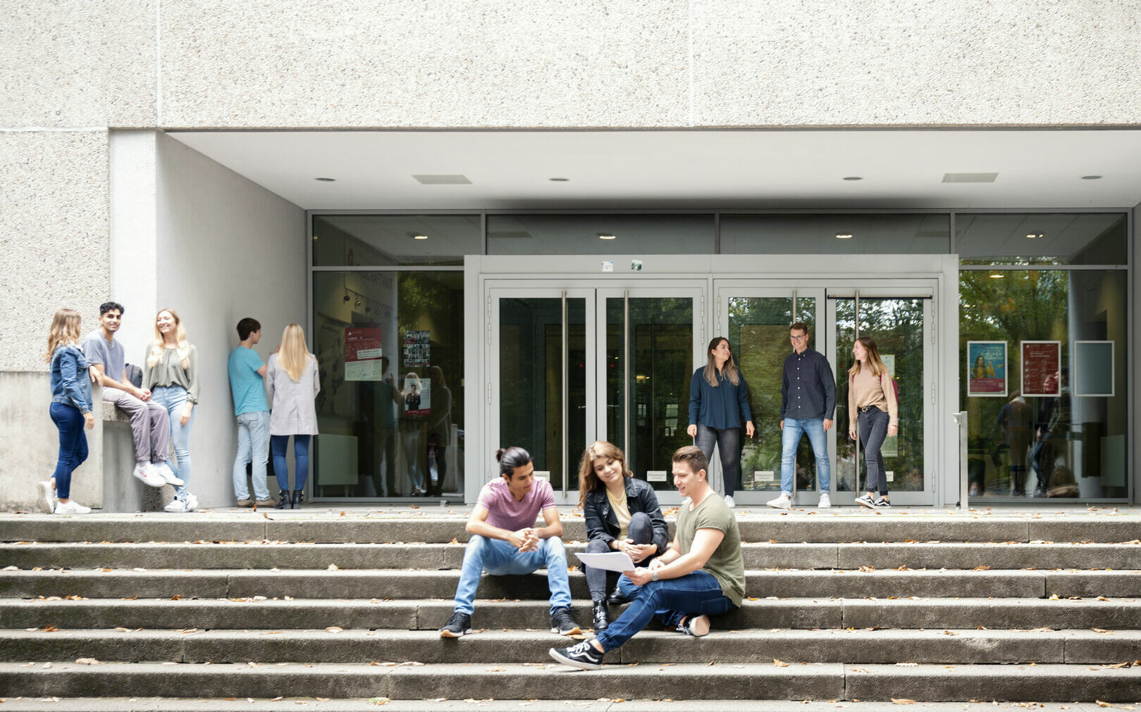 [Translate to English:] Studierende halten sich vor dem Eingang der Hochschule Karlsruhe auf