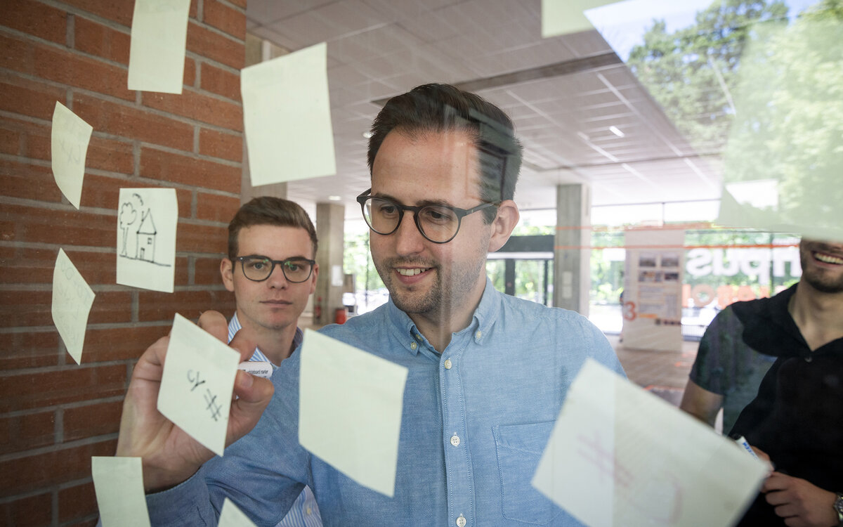 students seen through a glass panel with post-it stickers on it