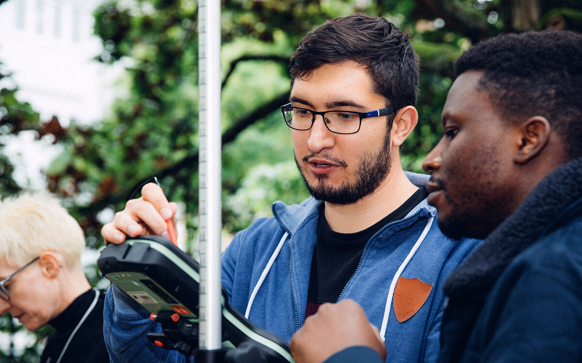 specialists taking measurements in the field with hand-held device