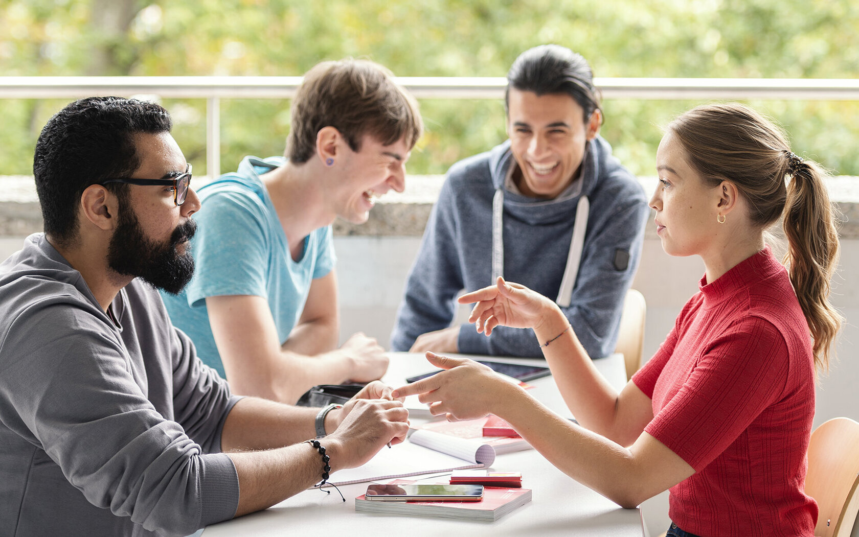 Laughing young people sitting at a table and working