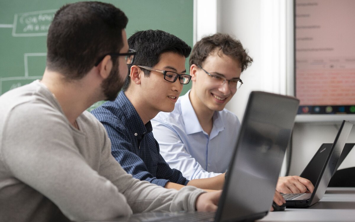 three students with laptops