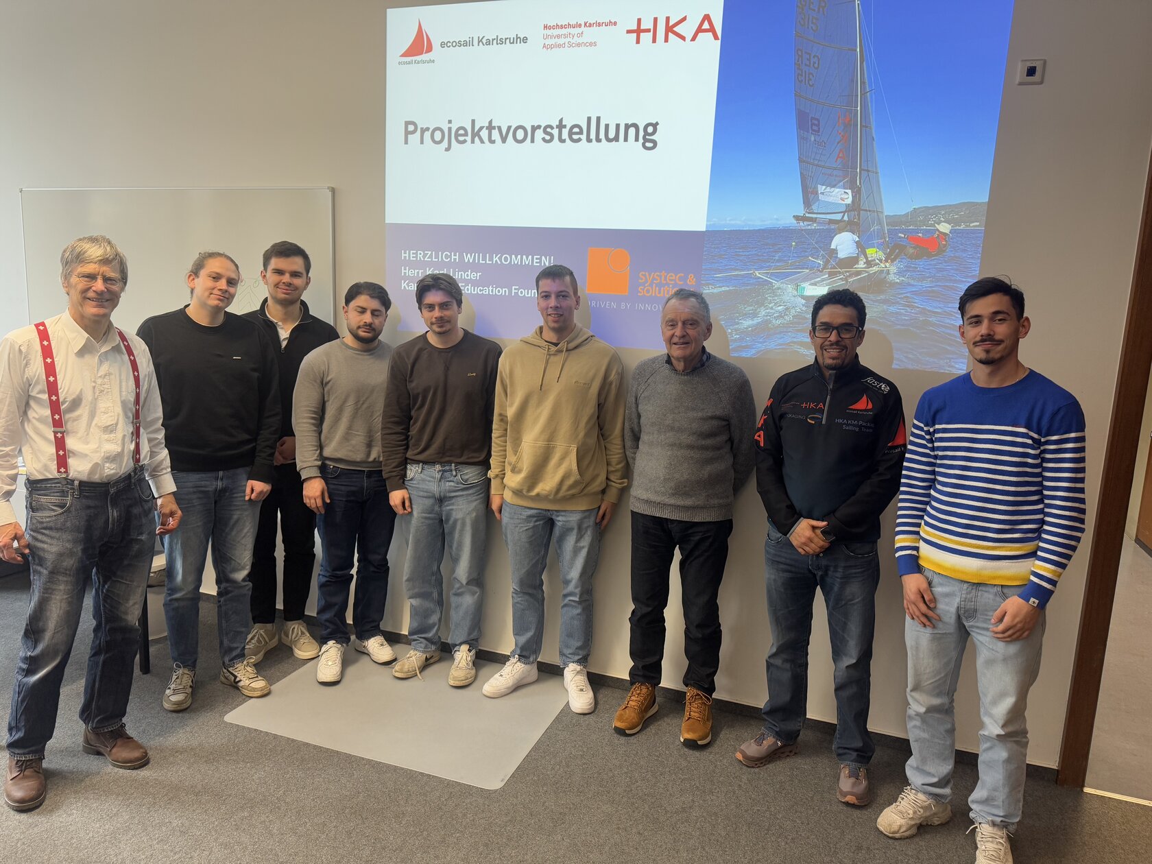 ecosail team standing in front of projection of a boat