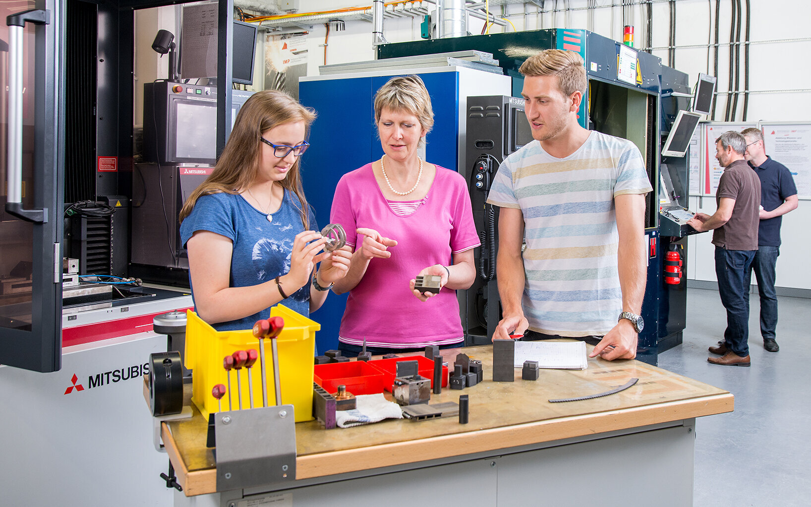 Professorin im Gespräch mit zwei studierenden während eines Laborversuchs