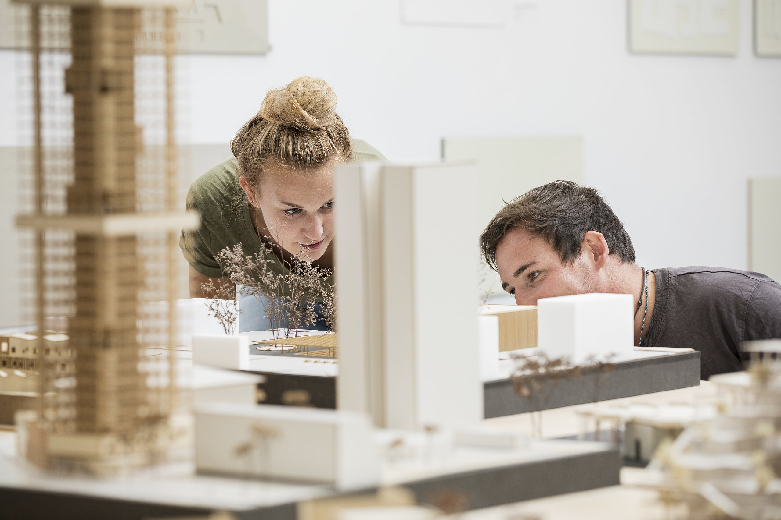 two students scrutinizing the model of a building