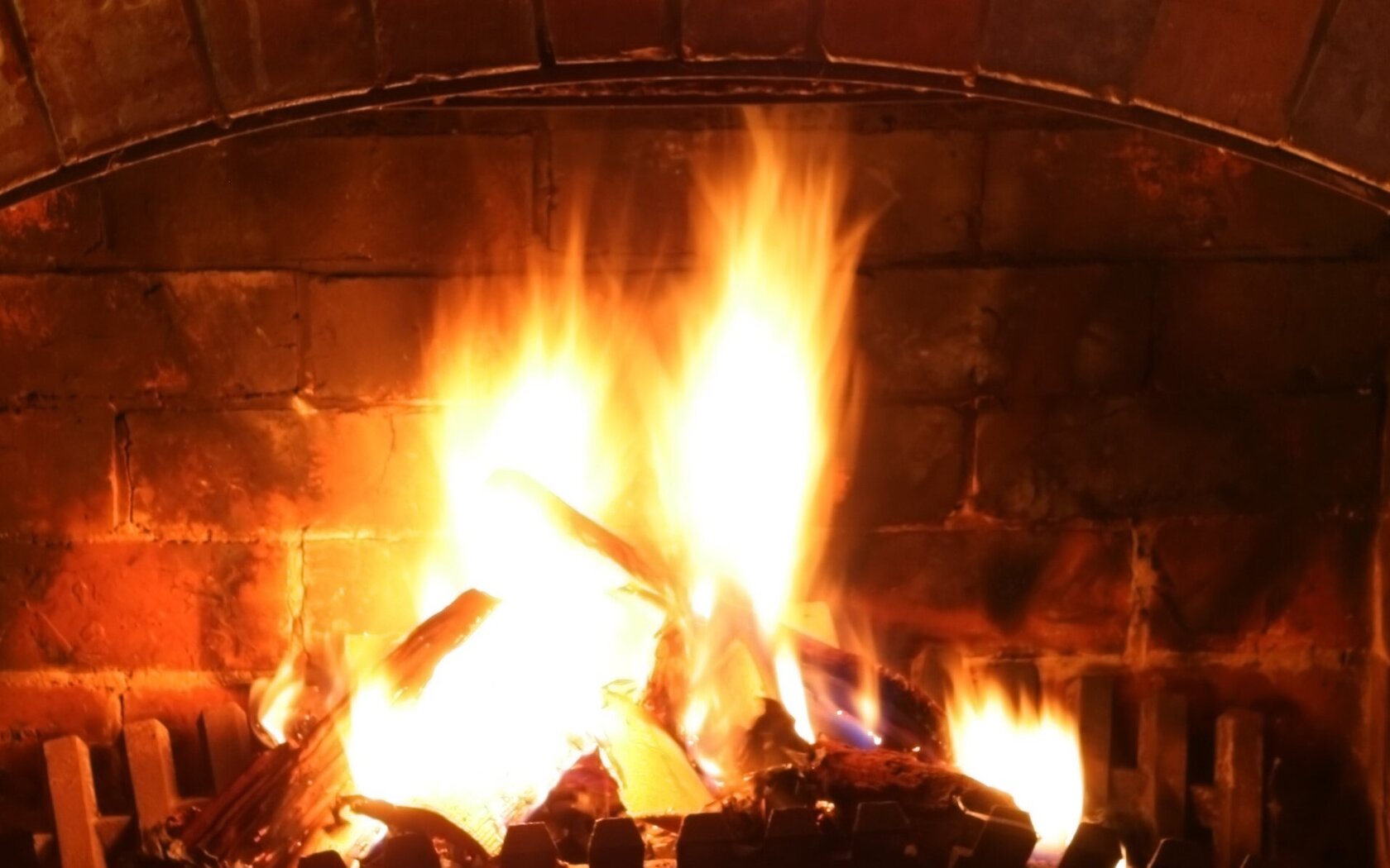 Log fire with Christmas garland and fairylights. Kaminfeuer