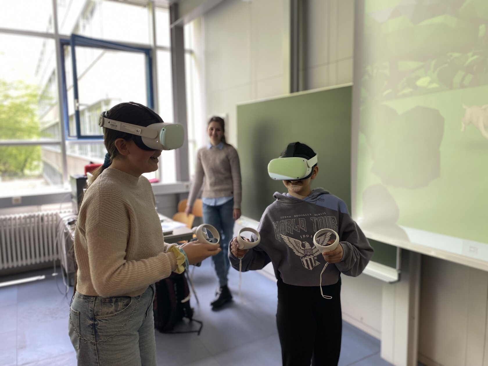 Zwei Teilnehmerinnen des Girls' Day probieren ihre Lernwelten in VR aus, nachdem sie von IIIX Mitarbeiterin Darja Stepanova (hinten) eine Einführung erhielten.