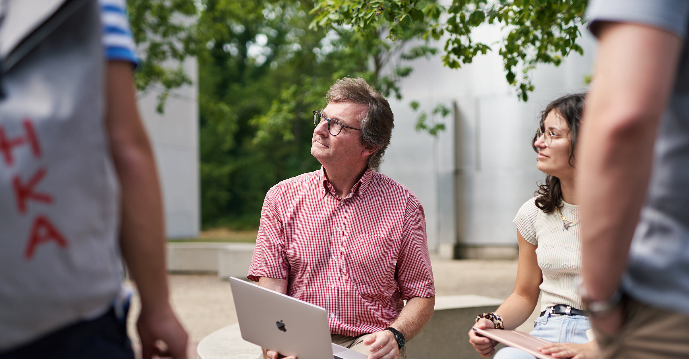 Professor im Gespräch mit Studierenden