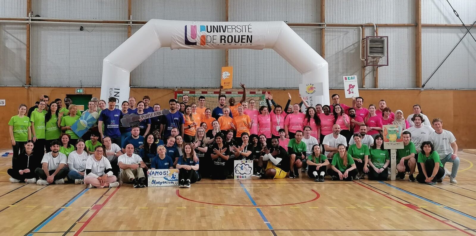 all participants posing in front of an inflatable portal with the hosting partner's logo. They wear t-shirts in the INGENIUM colours
