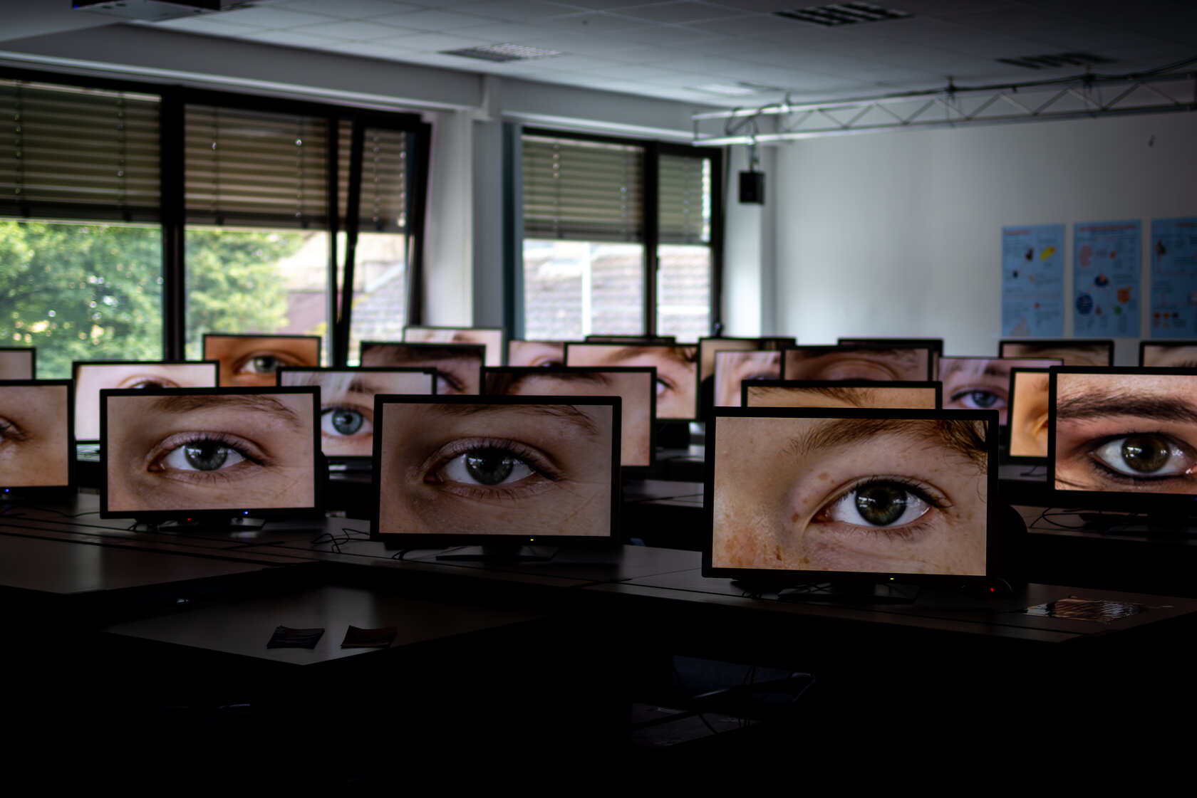Raum voller Bildschirme, auf denen einzelne Augen zu sehen sind.